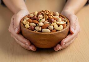 Bowl of assorted nuts held by hands in a cozy setting photo