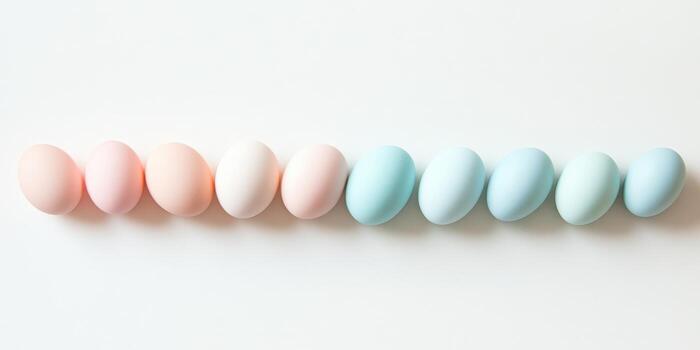 Pastel-colored easter eggs lined up on white background highlighting minimalism photo