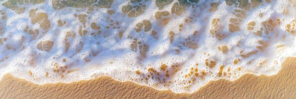 Aerial view of gentle ocean waves meeting sandy shoreline in daylight photo
