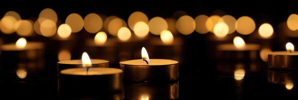 Soft glow of multiple lit candles illuminating a dark background for tranquil atmosphere photo