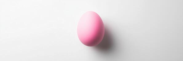 Pink egg on white background highlighting minimalist concept and easter symbolism photo