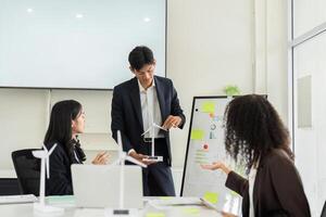 ESG Presentation and Renewable Energy Insights. A speaker presents sustainable initiatives using a model in a board meeting. photo