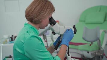 Gynecologist using colposcope, magnifying optical device designed for thorough examination of cervix, vagina, and vulva, helping to diagnose abnormalities and detect precancerous conditions. video
