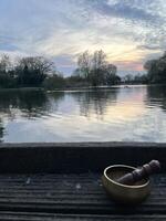 Mindful meditation with a singing bowl by the lake photo