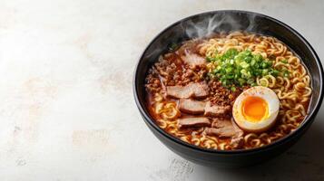 Bowl filled with ramen noodles topped with green onions and soft boiled egg photo