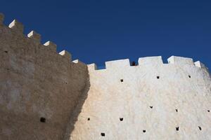 Curved defensive wall of agadir fortress with battlements in agadir morocco photo