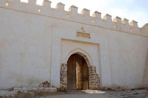 Main wooden entrance to agadir oufella fortress with archway and brick details morocco photo