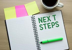 Next steps on notebook with pen, coffee and notepad next steps concept photo