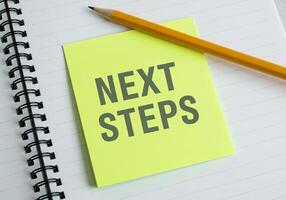 Next steps on a notebook with pencil photo