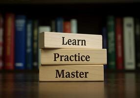 A stack of wooden blocks with the words learn practice master photo