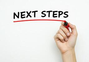 Next steps - hand writing the word next steps with marker on transparent screen photo
