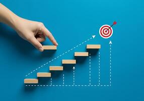 Hand reaching up to a target on a wooden staircase photo