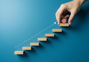 Hand pushing up a stairway with a target on top photo