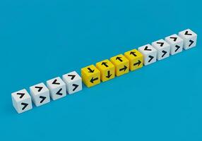 A row of yellow dice with arrows pointing in different directions photo