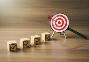 A target with an arrow on a wooden block and check boxes photo