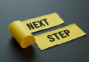 Next step on yellow tape on black background photo