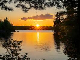 a sunset over a lake with trees in the background photo