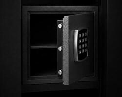 Metal safe box in the closet. Small narrow safe for keeping money or valuables in the hotel. Open safe door with buttons for entering a password. Compact strongbox inside cabinet. Empty safe. photo