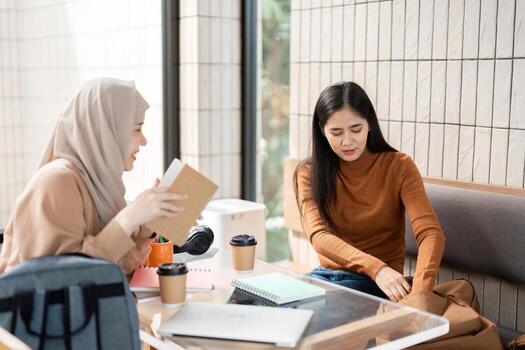 Support and Conversation. A caring friend engages with another over coffee while discussing their studies. photo