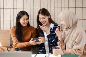 Sharing and Laughter. Friends discuss ideas while reviewing content on a mobile device. photo