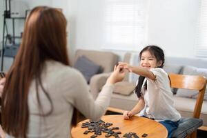 Playful Learning and Family Interaction. A girl enjoys a game while developing skills with her mother by her side. photo