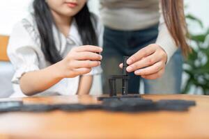 Togetherness in Learning. A mother helping her daughter build strategies while playing with dominos. photo