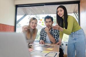Diverse design team reviewing digital mockups and collaborating in bright office. photo