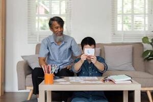 Interactive Learning and Family Connection. A grandfather helps his grandson with Down syndrome learn letters. photo