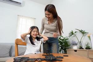Joyful Play and Learning. A playful moment between a mother and her daughter brings smiles and laughter during game time. photo