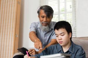 Interactive Learning Experience. A grandfather enthusiastically engages with his grandson during a study session. photo