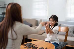 Educational Play and Interaction. A girl eagerly participates in a game, learning valuable skills with her mother. photo