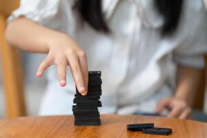 Learning and Creativity. A motivated child focuses on building a stack with game pieces, encouraging cognitive skills. photo