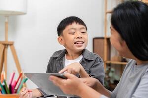 Interactive Learning and Engagement. A child happily interacting with a parent while using a tablet. photo