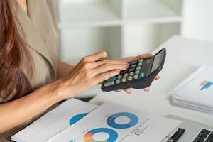 Financial Planning and Calculator Use. A woman analyzing financial data using a calculator and spreadsheet. photo