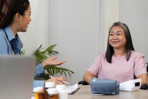 Dialogue and Patient Interaction. A nurse engages with a senior patient, fostering connection during a health check. photo