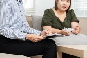 Psychiatric Assessment and Healing Dialogue. A psychiatrist takes notes while engaging with a patient in a supportive discussion. photo