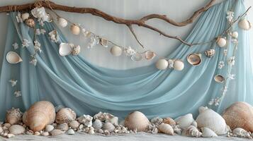 Coastal Photography Backdrop with Soft Aqua Blue Fabric Drapery, Natural Driftwood Branch, Seashell Garlands and Beach Sand Arrangement photo
