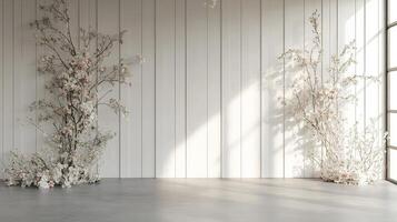 Soft Romantic Floral Installation Featuring White and Blush Flowers on Tall Branches Framing a Minimal White Wall in Natural Sunlight photo