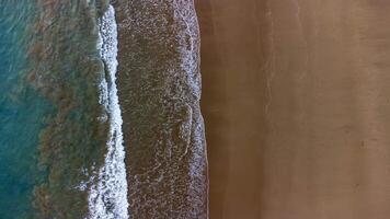Aerial View of Waves Crashing on Sandy Beach, Beautiful Beach at Lenggoksono Beach photo