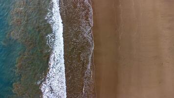 Aerial View of Beautiful Waves Crashing on Sandy Beach at Lenggoksono Beach photo