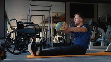 Man with disability doing core workout with medicine ball on mat video
