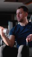 Wheelchair user lifting dumbbell during bicep workout video