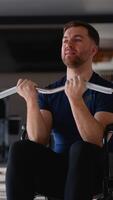 Man in wheelchair training biceps with curl bar video