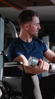 Wheelchair user doing bicep curl with dumbbell in gym video