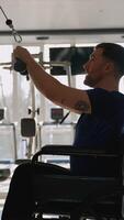 Man in wheelchair using cable machine in gym video