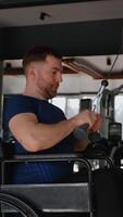 Man in wheelchair training biceps on cable machine video
