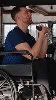 A man in wheelchair performing bicep curls on a cable machine at the gym video