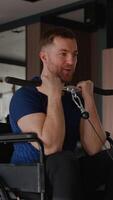 Wheelchair user doing arm curls with bar in gym video