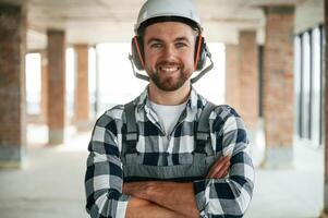 Portrait, in ,hard ,hat. Construction worker in uniform in empty unfinished room photo
