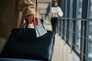 Man arrives, from the, flight in the airport entrance hall, woman is meeting him with name blank photo